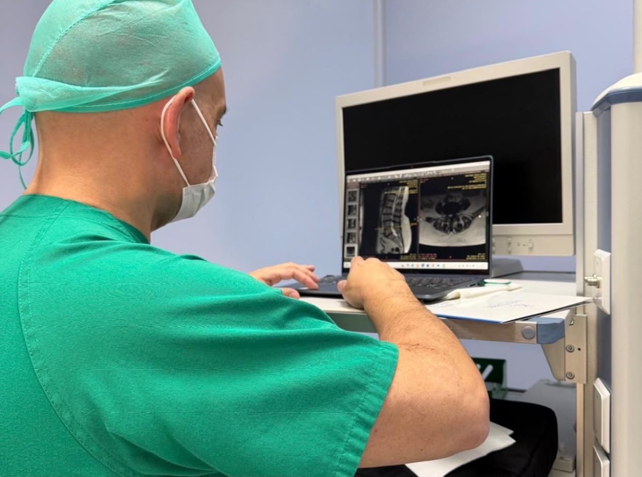 Dr. Bernardo Mosqueira explicando a un paciente el origen de una compresión nerviosa lumbar durante una consulta especializada de columna