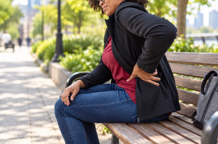 Persona sentada con dolor lumbar tras presentar dificultades para caminar